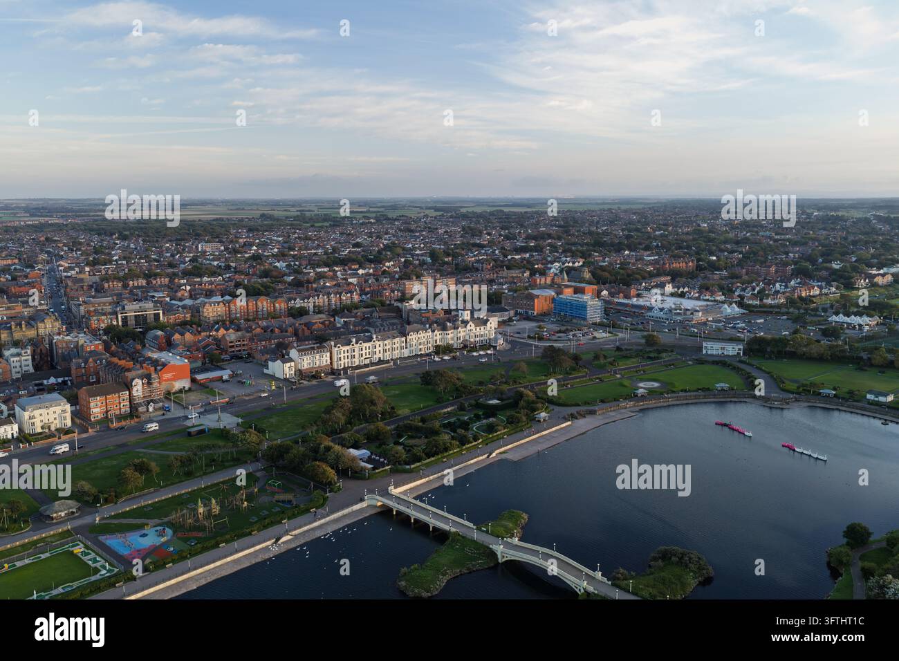 Aerial view of a coastal town featuring a large lake, a pedestrian ...