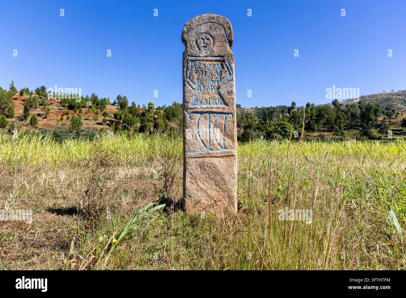 A traditional carved stone memorial marker painted with blue ...