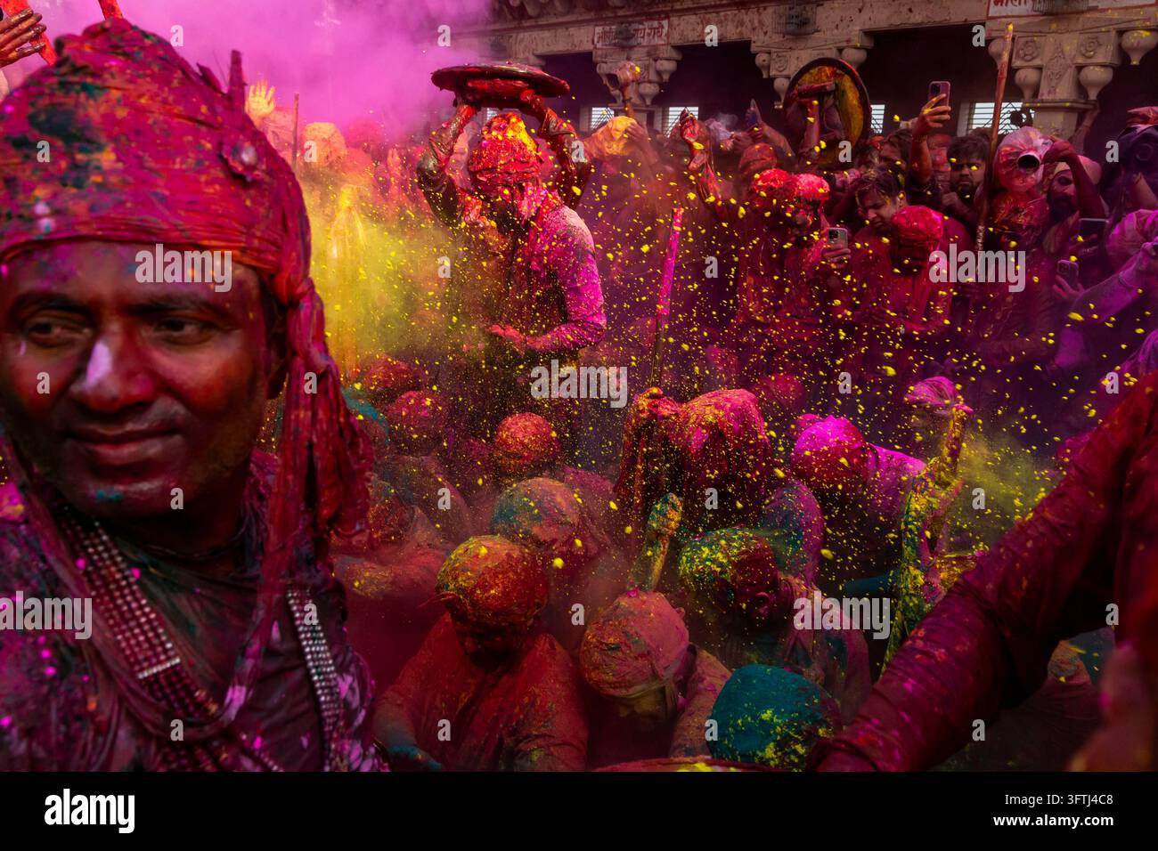 Man in magenta scarf with powder in his face and flying color at Braj ...