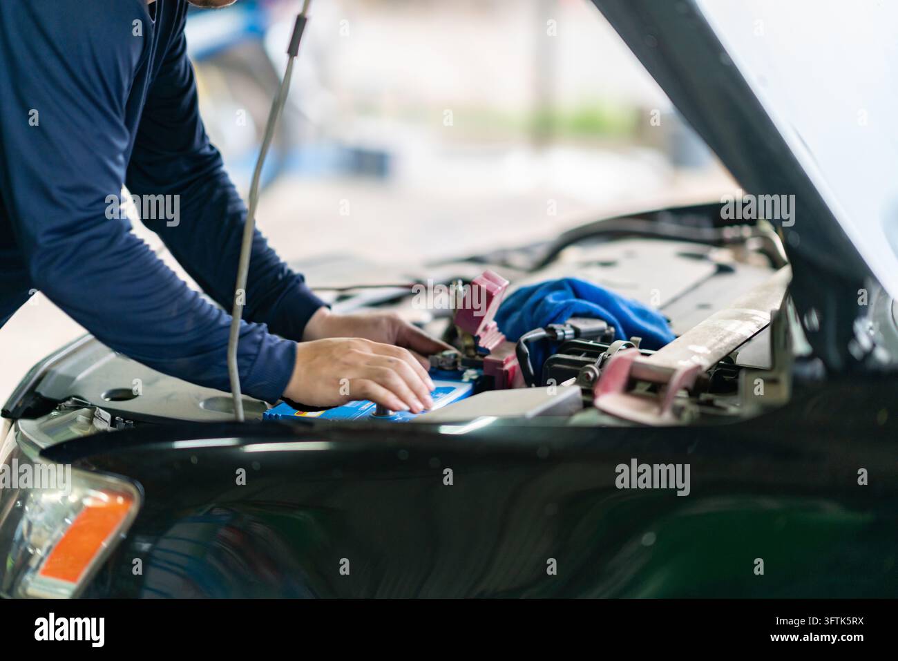 Cropped view of a professional technician performing routine engine ...