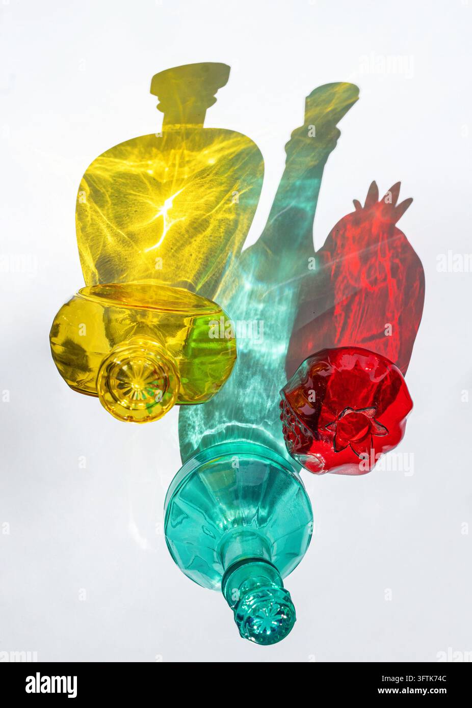 Colorful Glass Bottles Casting Vibrant Shadows on White Stock Photo