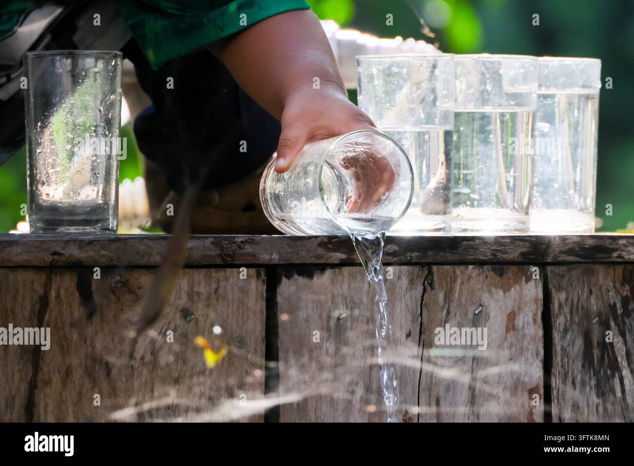 Reflection Image Bright An adult person pours clear water from glass over weathered wooden ...