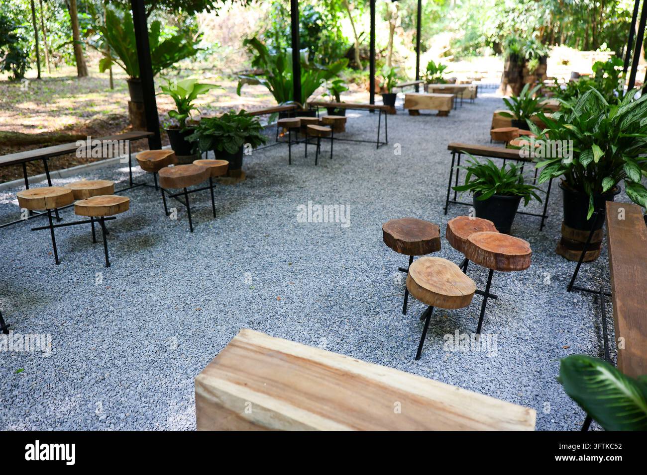 An outdoor garden cafe with wooden table, stump stool, gravel patio ...