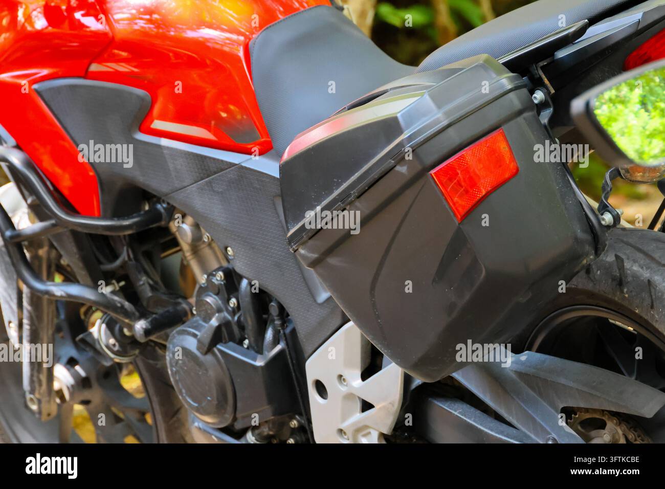 A red motorcycle with black side case, engine, seat, mirror, and rear ...