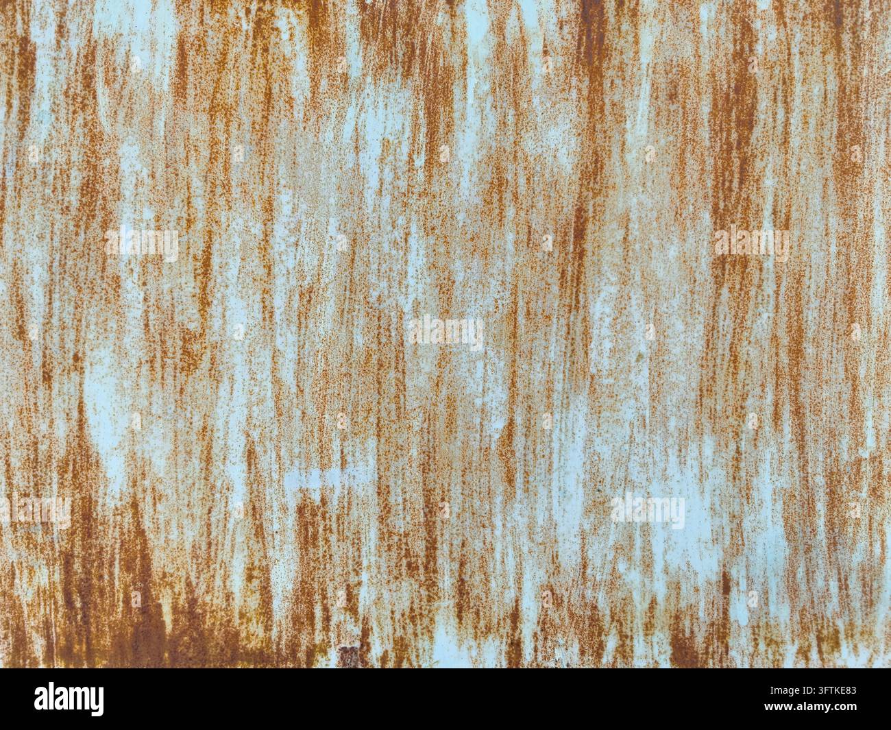 Abstract weathered surface with peeling pale blue paint and dense rust ...