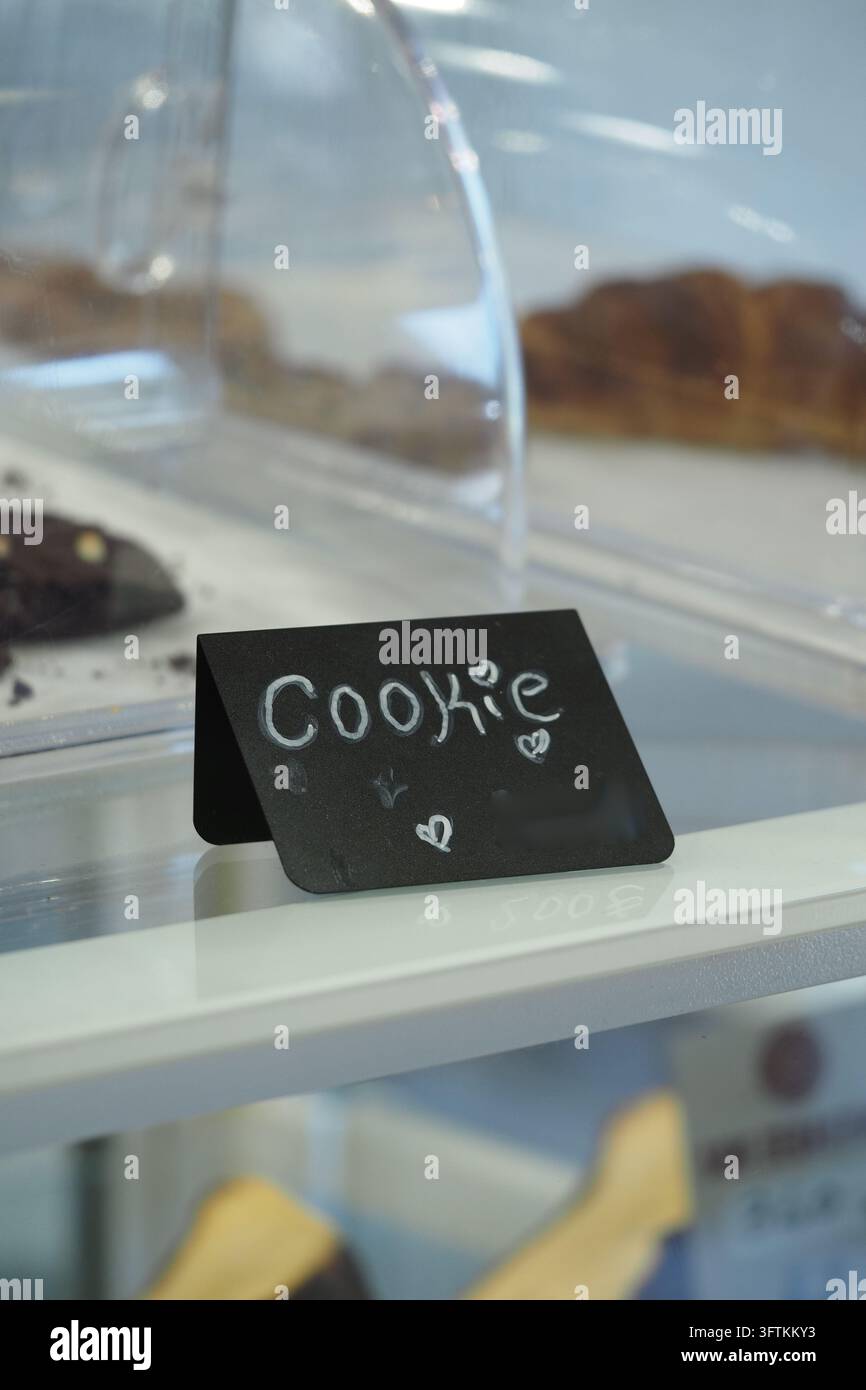 Cookie sign on display in a bakery with various desserts Stock Photo ...