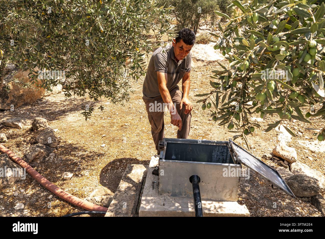 A Palestinian from the West Bank checks a metal watering can in the ...