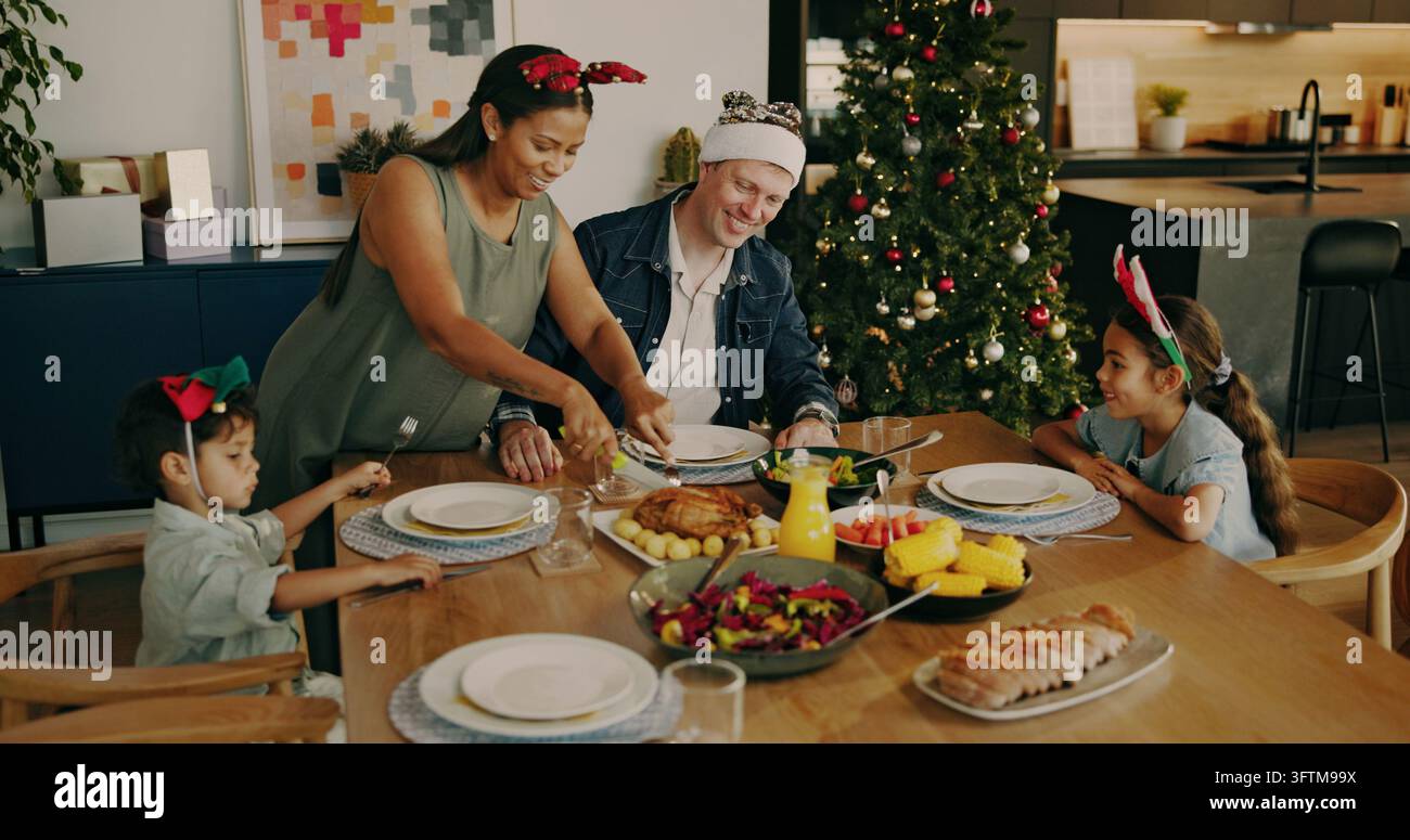Christmas, parents and kids with chicken for serving, festive feast or ...