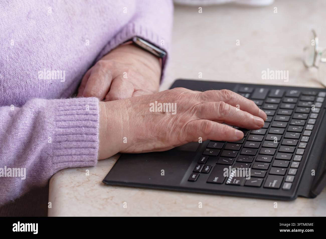 Hands of senior person type on computer keyboard. Distance ...