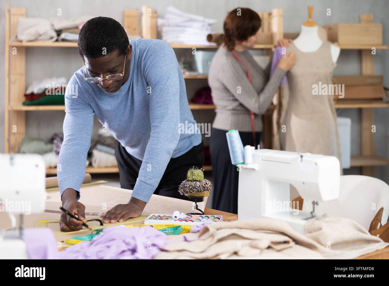 African American man tailor draw dress pattern on paper. Craftsman ...