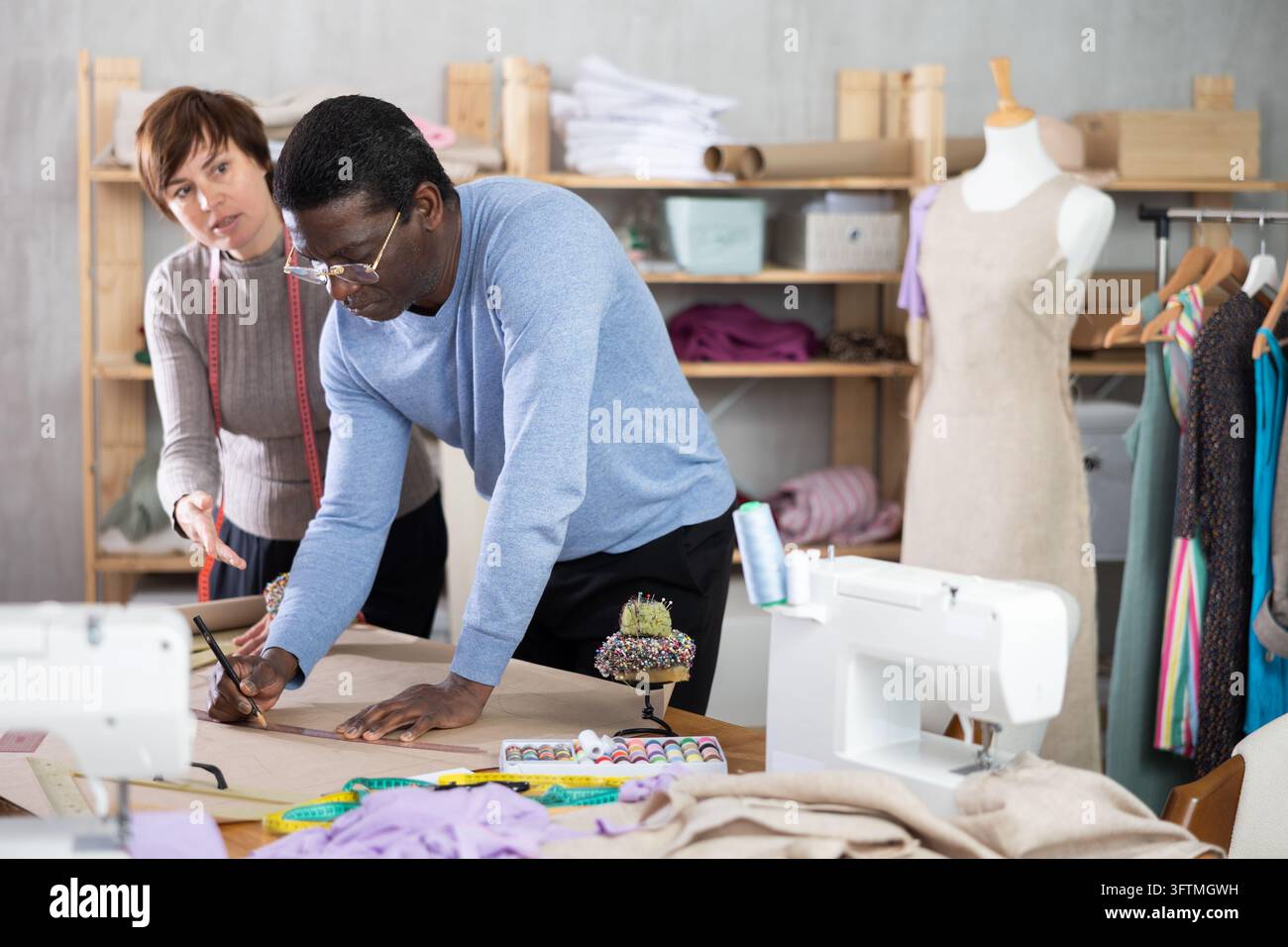Woman tailor draw dress pattern on paper and participate in creating ...