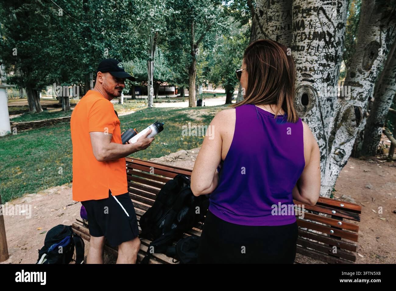 Couple hydrating and discussing their fitness goals after a training ...