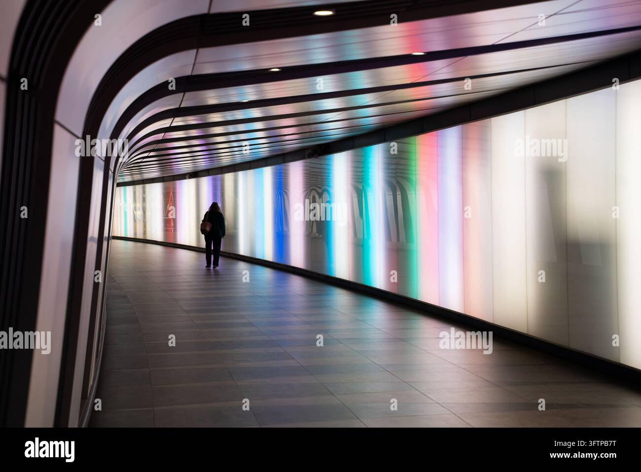 View of a person walking through the illuminated Kings Cross Tunnel ...