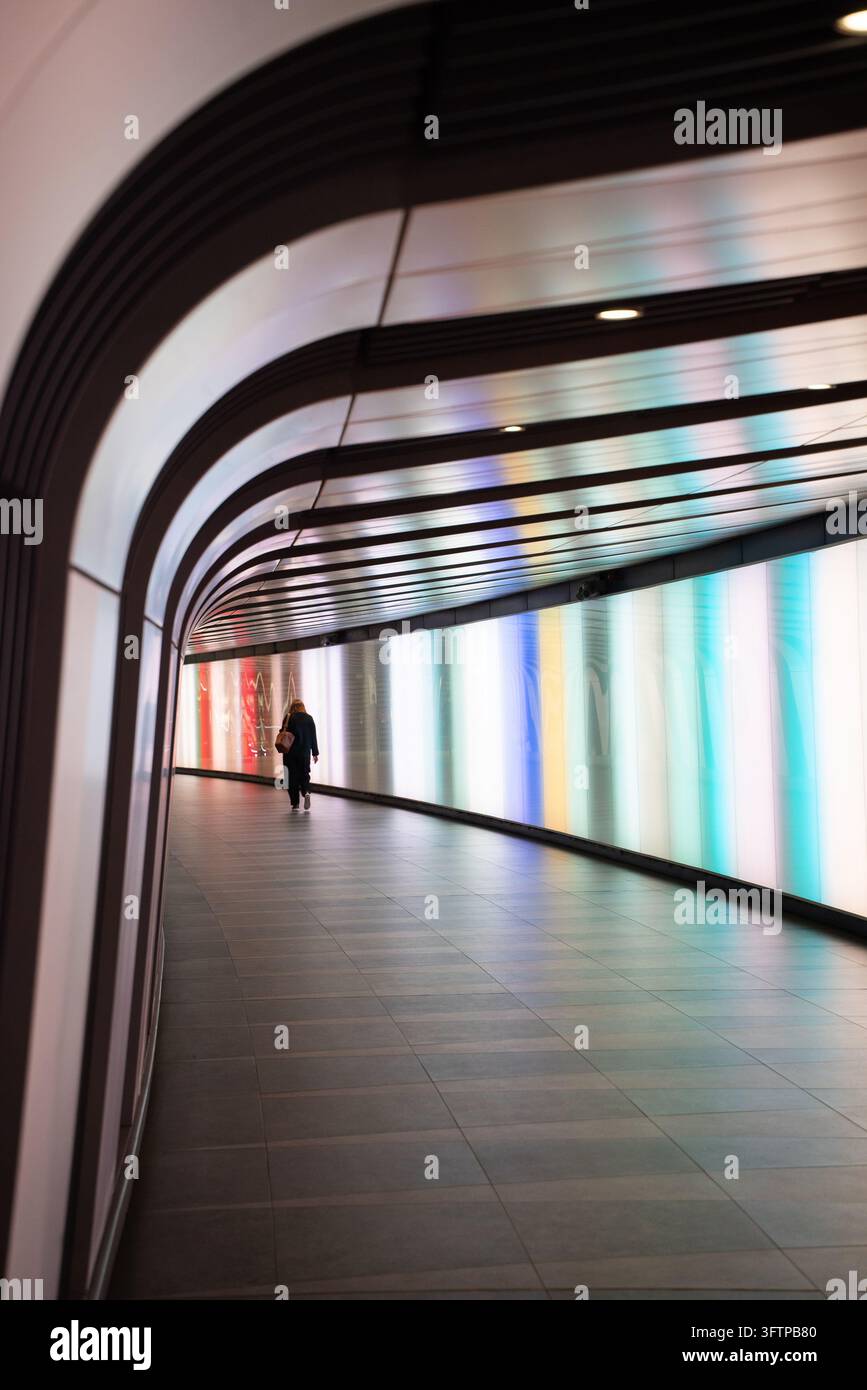 View of a person walking through the illuminated King's Cross Tunnel ...