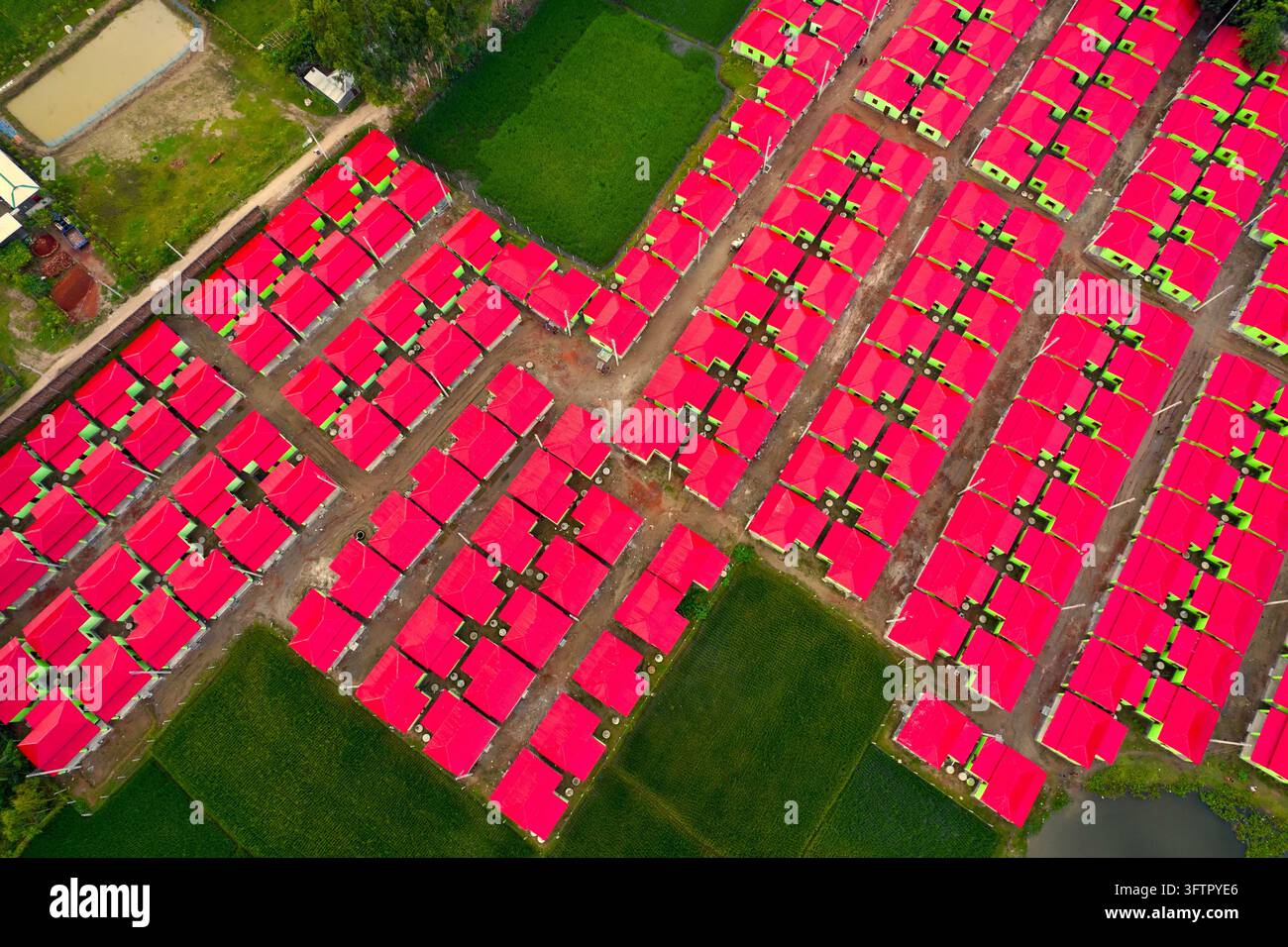 Aerial view of a dense housing development featuring rows of identical ...