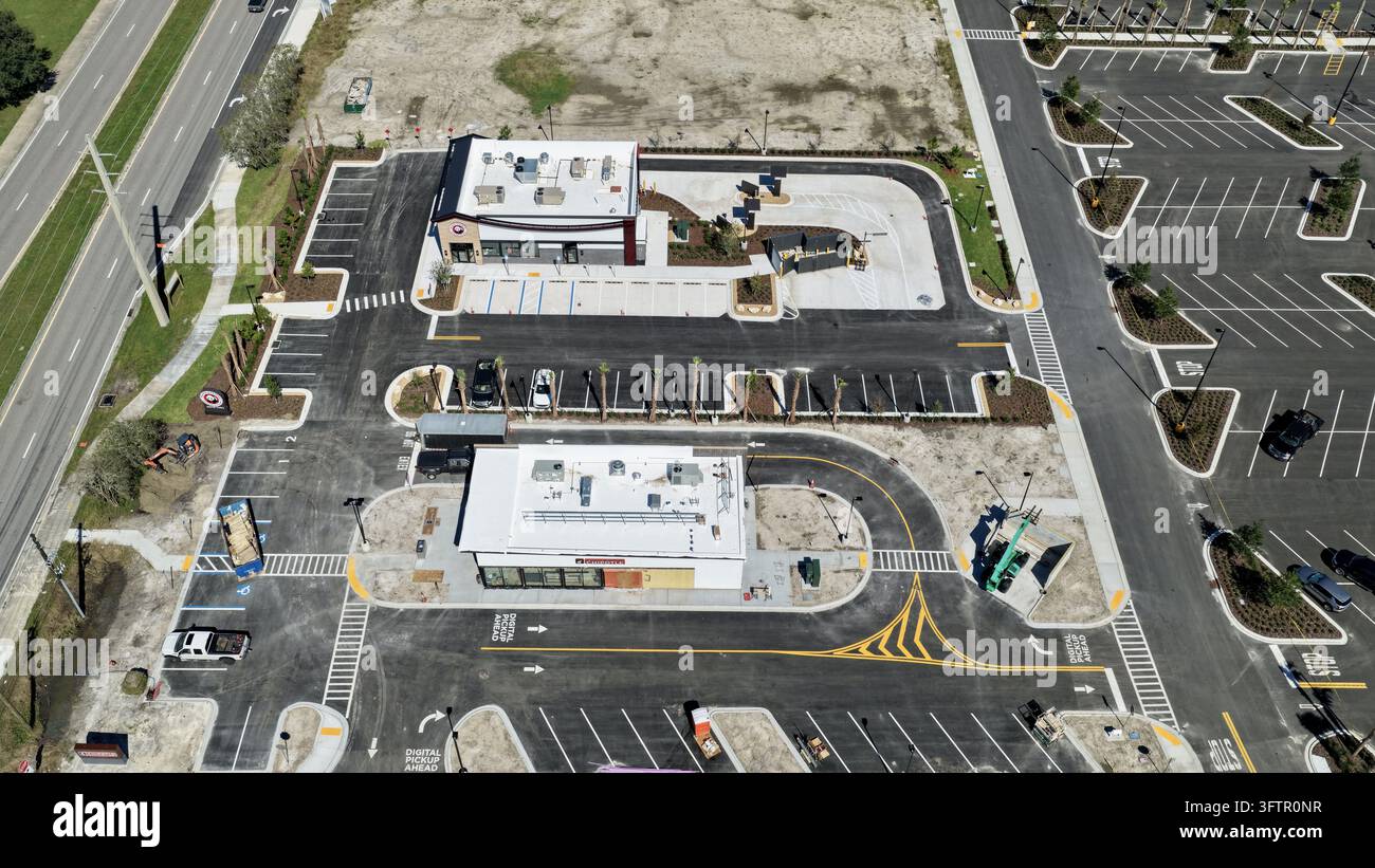 Aerial view of a commercial development with drive-thru lanes, parking ...