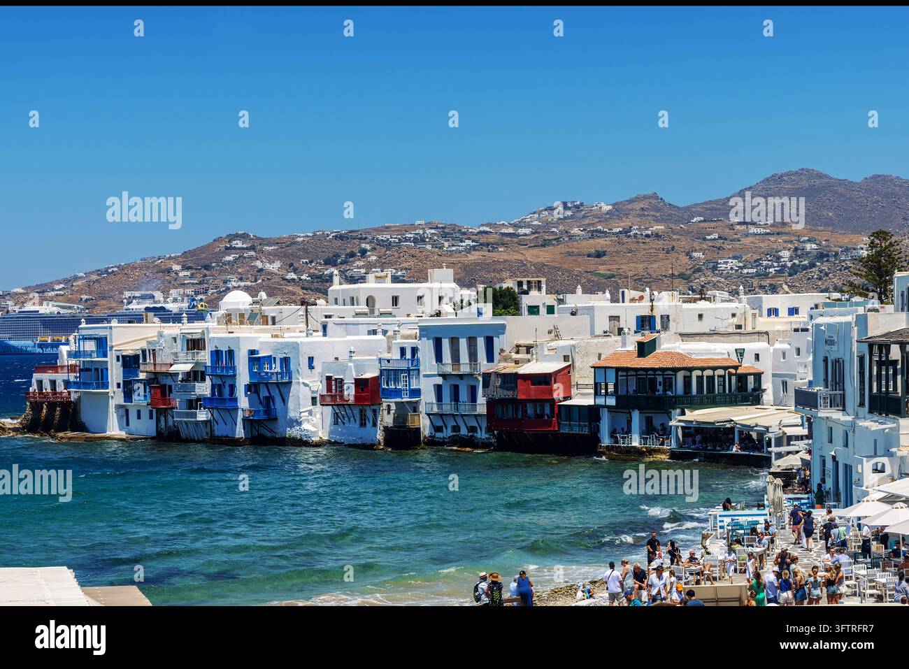 Mykonos, Greece - July 16, 2026: Visitors walk along the waterfront of ...