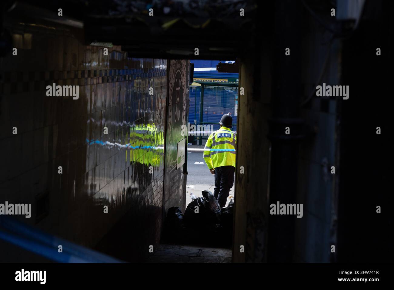 Police officers seen down an alley way in a crime scene after a Police ...