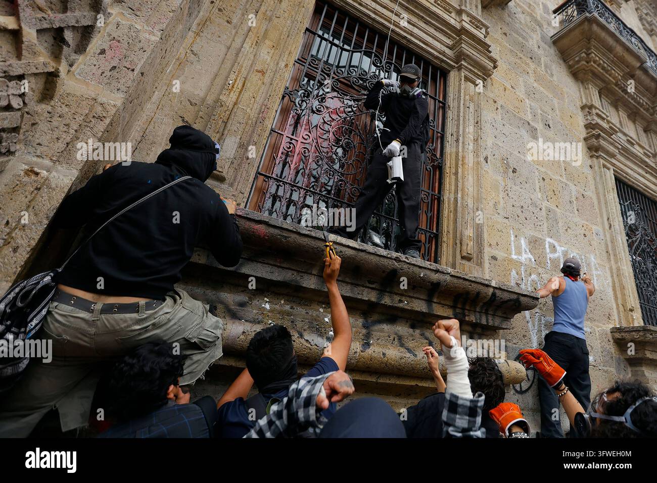 A protester displays a security camera that was torn from the ...