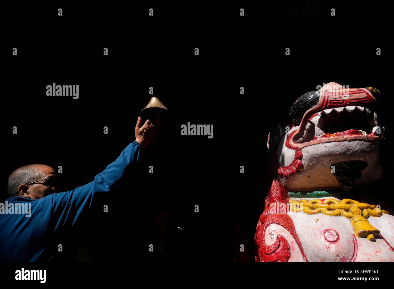 A devotee rings the bell hanging outside Naradevi Temple after offering ...