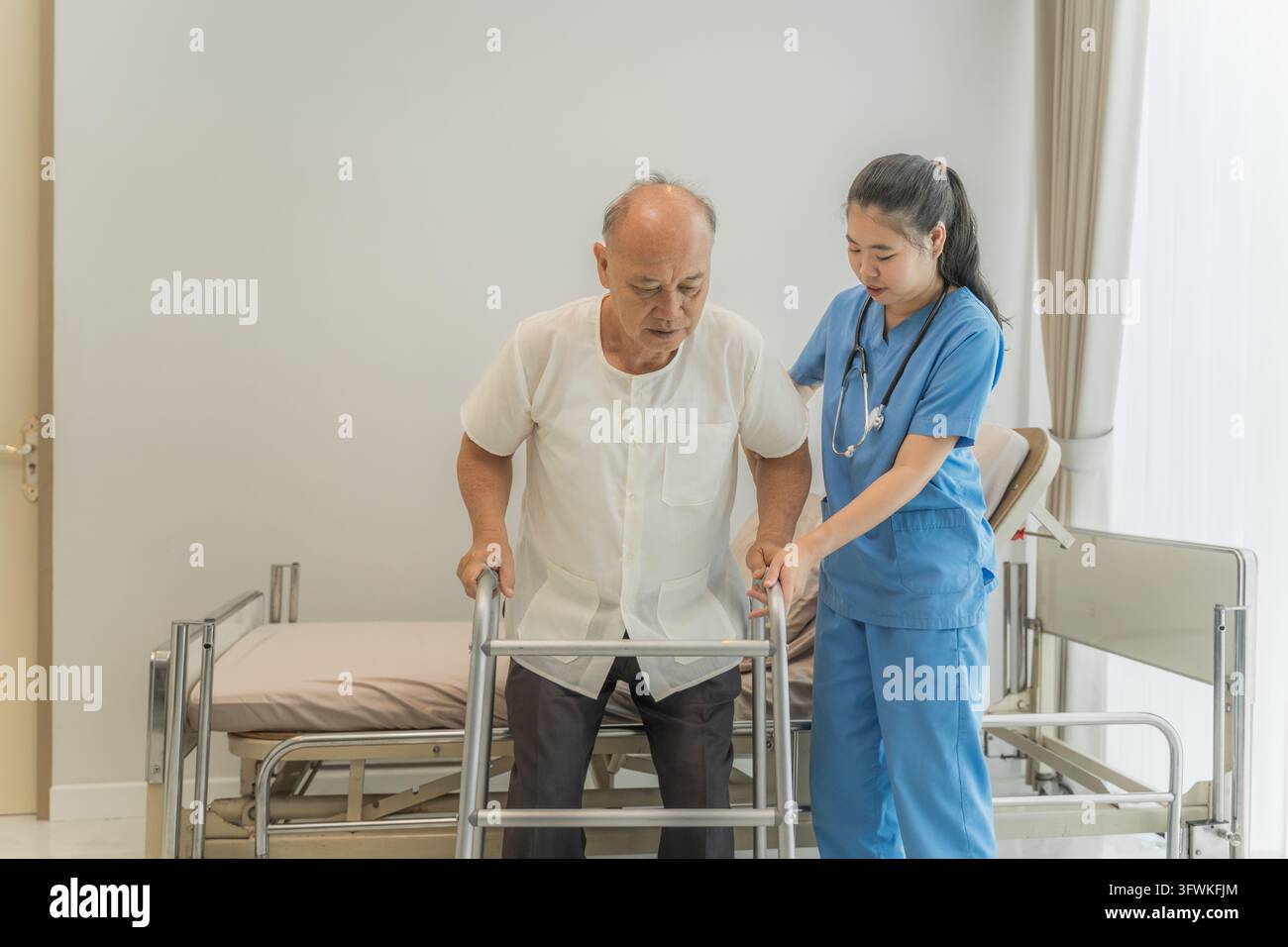 Senior man using a walker assisted by a nurse in a rehabilitation ...