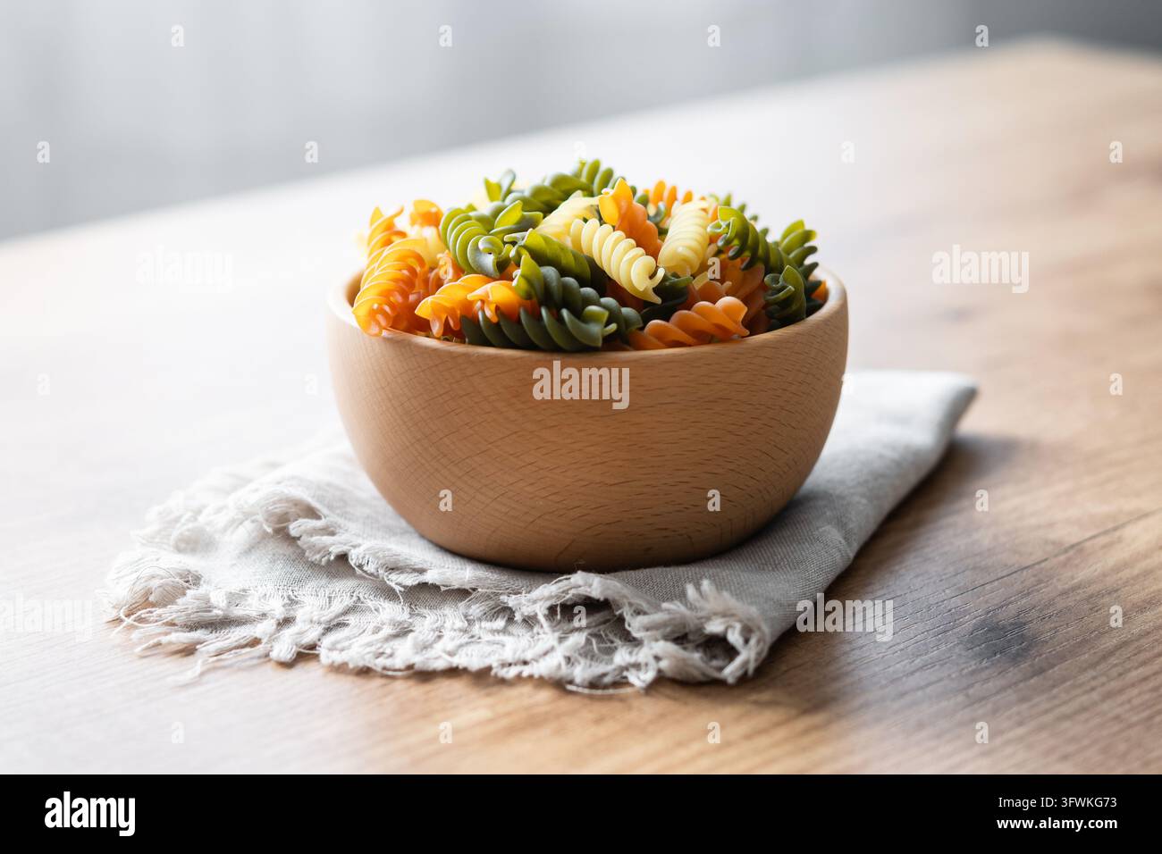 Dry tricolor fusilli pasta on wooden table Stock Photo - Alamy