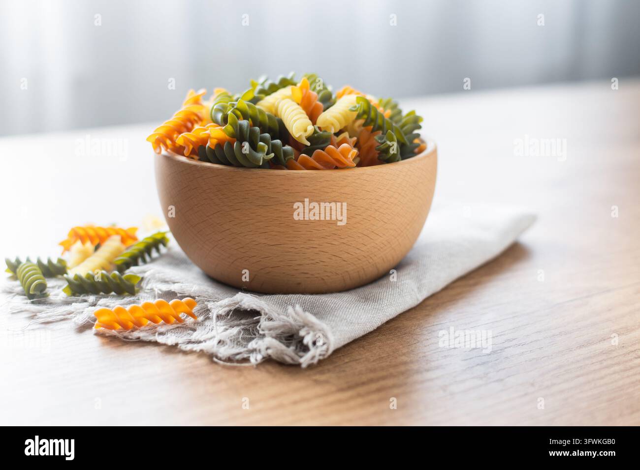 Dry tricolor fusilli pasta on wooden table Stock Photo - Alamy