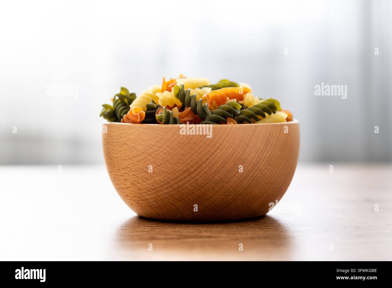 Dry tricolor fusilli pasta on wooden table Stock Photo - Alamy