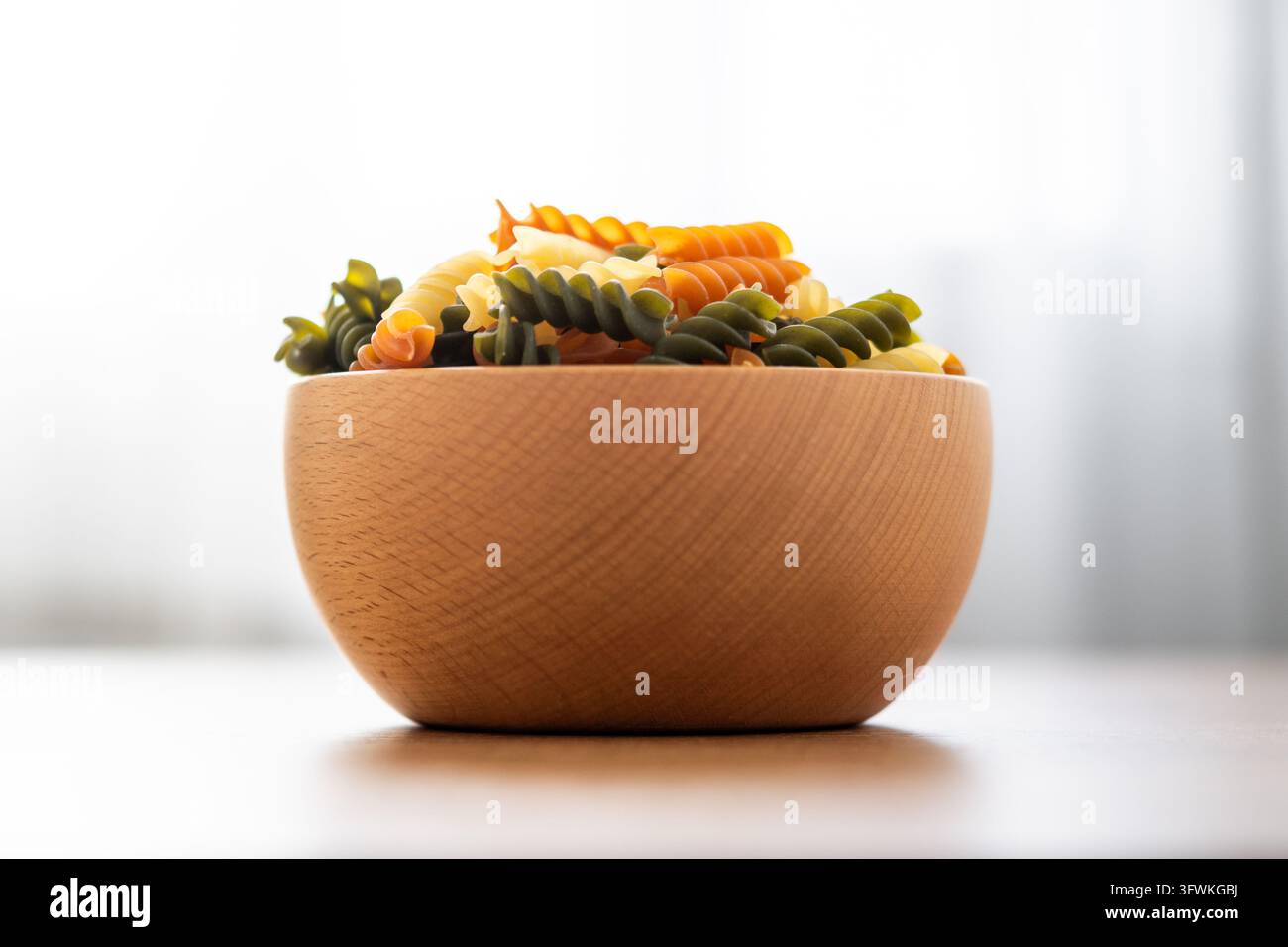 Dry tricolor fusilli pasta on wooden table Stock Photo - Alamy