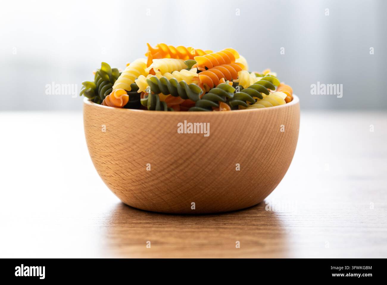 Dry tricolor fusilli pasta on wooden table Stock Photo - Alamy