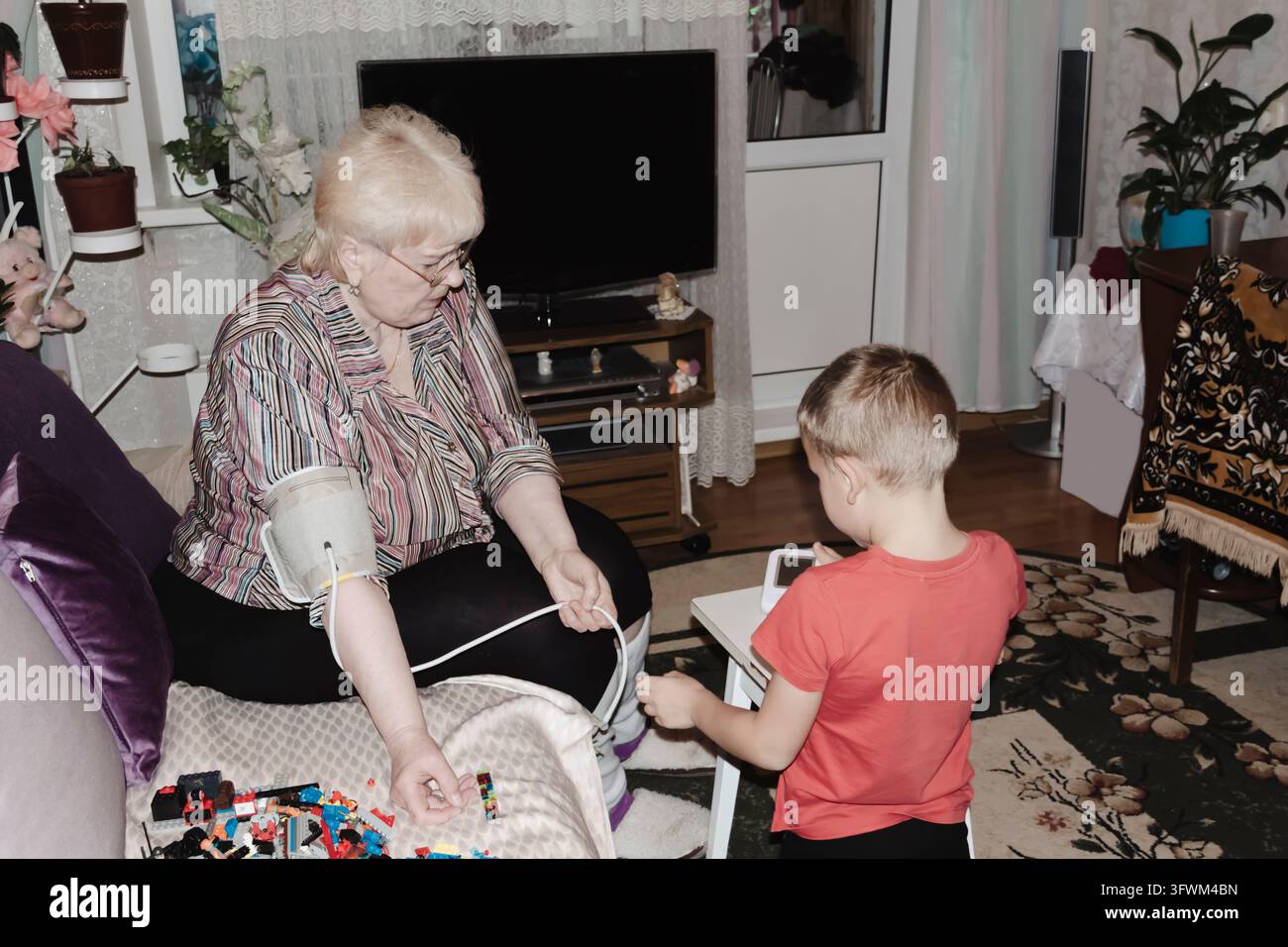 An elderly woman with hypertension measures her own blood pressure at ...