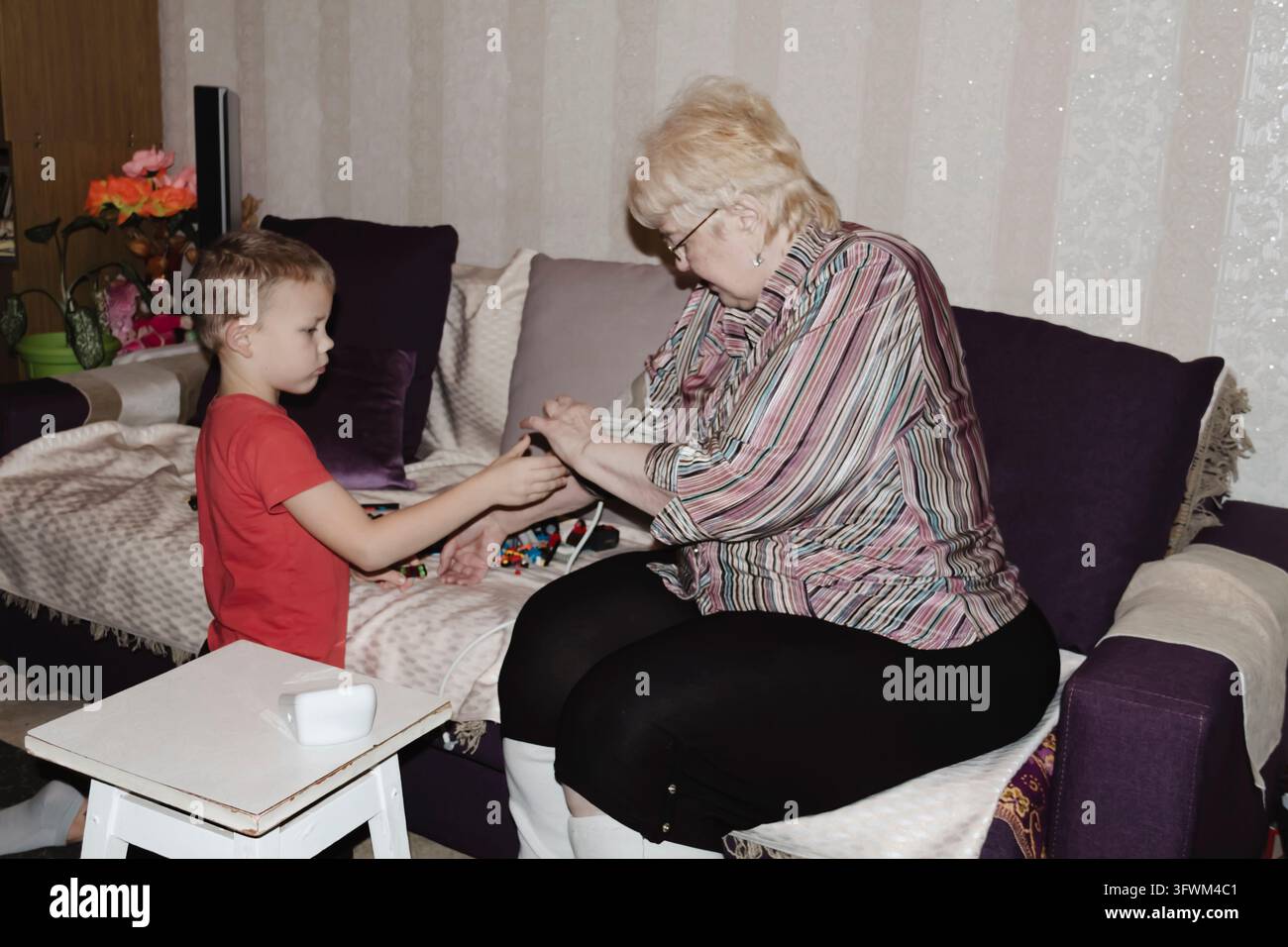 An elderly woman with hypertension measures her own blood pressure at ...