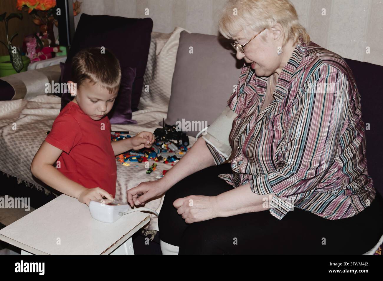 An elderly woman with hypertension measures her own blood pressure at ...