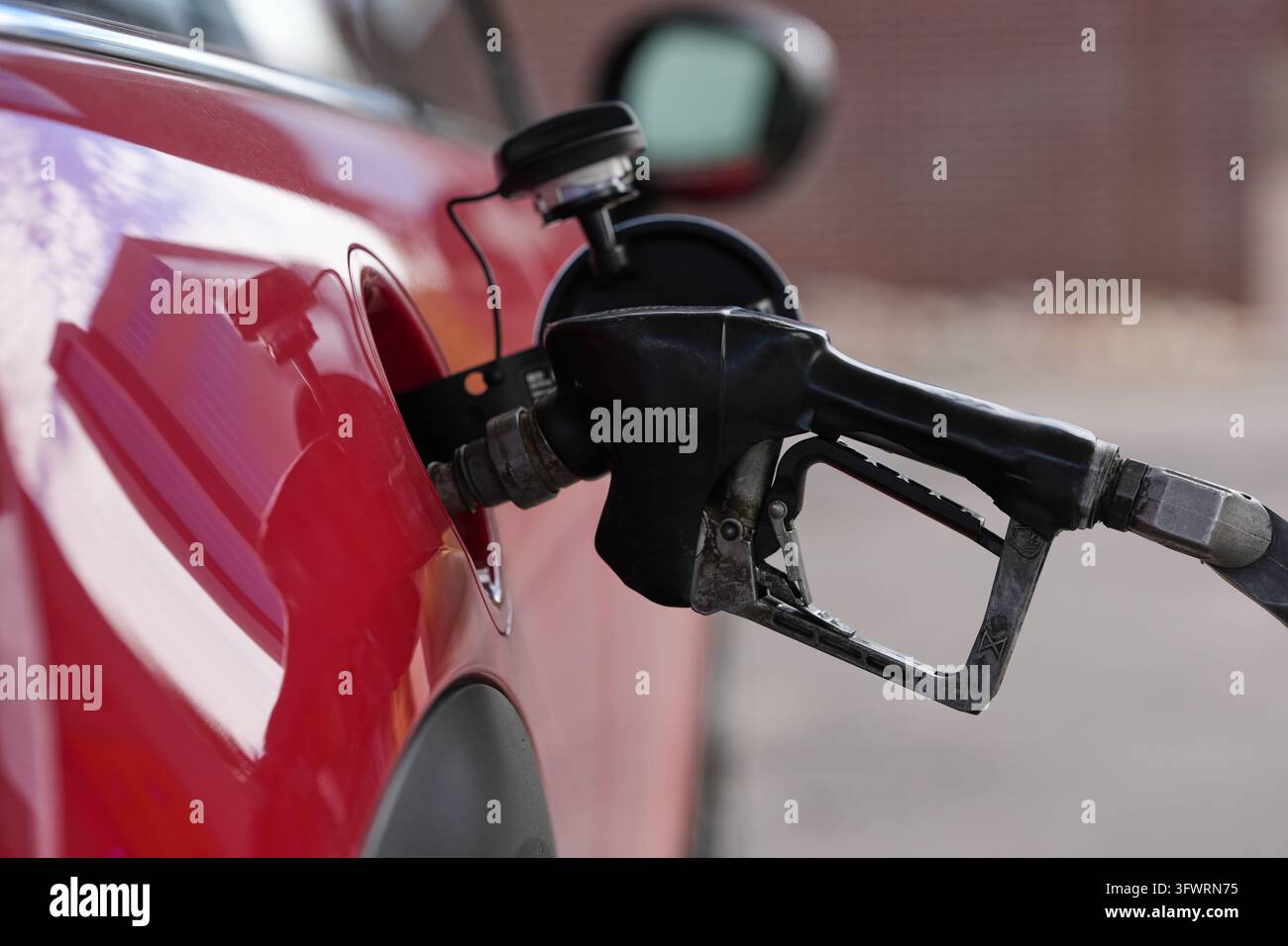 A motorist fills up the tank of a vehicle at a Shell gasoline station ...