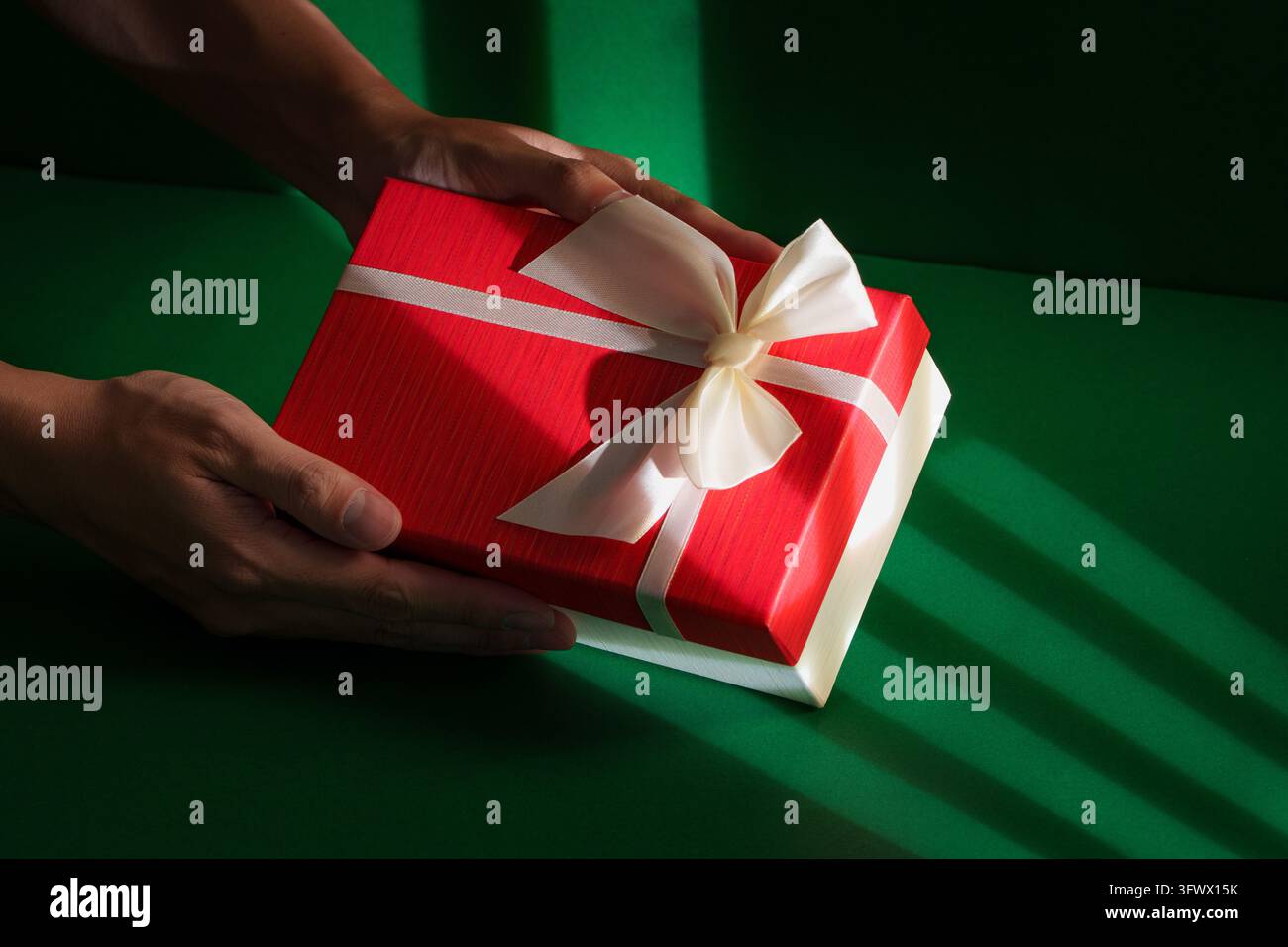 Holiday gift box held in hands with a white ribbon Stock Photo - Alamy