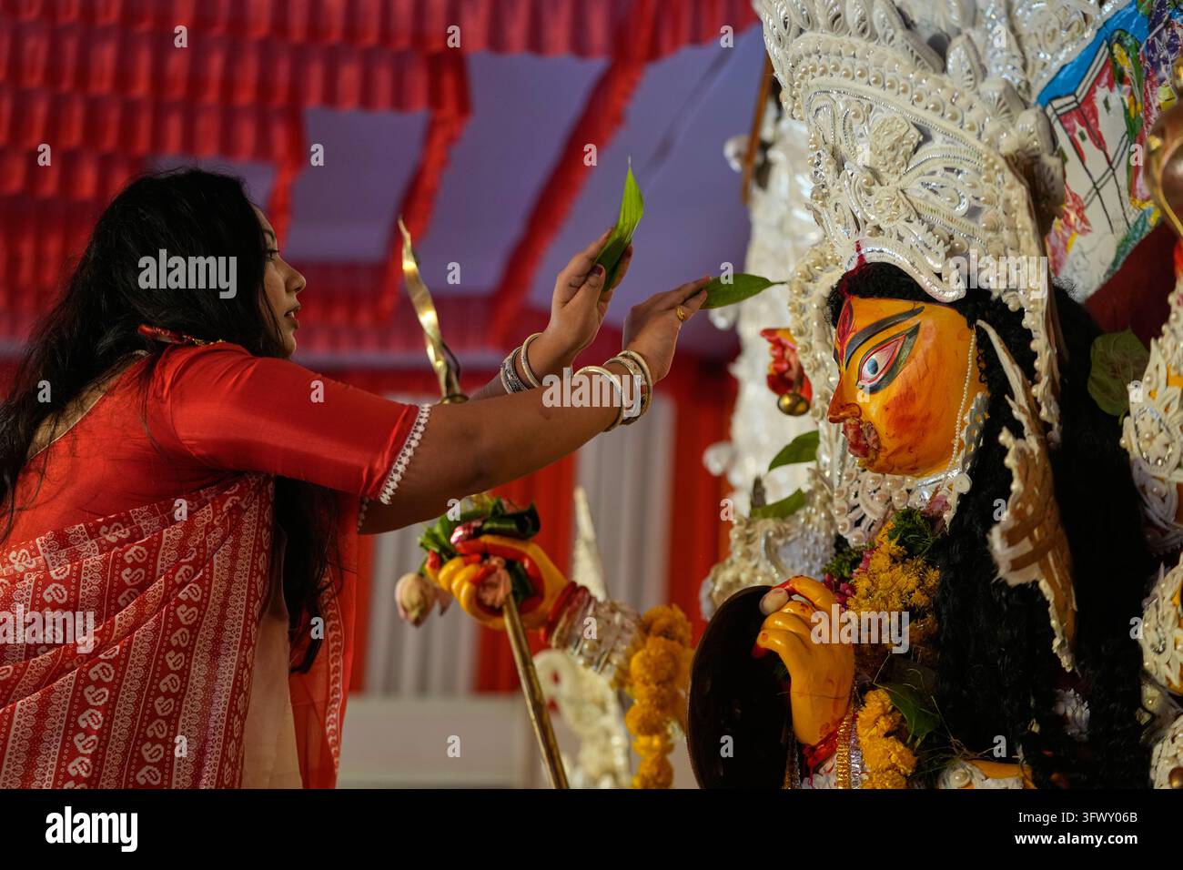 A Hindu devotee performs rituals on the last day of the Durga Puja ...