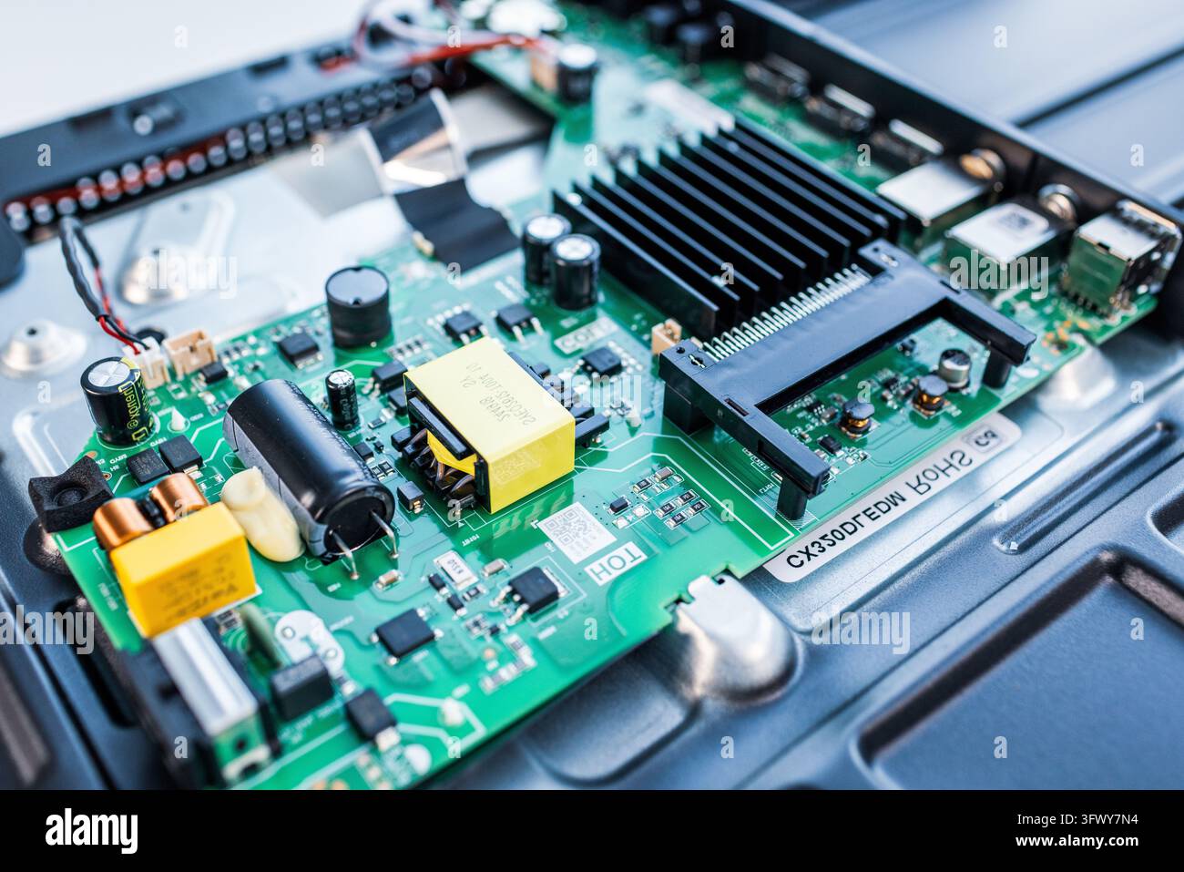 Green circuit board showing various electronic components inside a device Stock Photo