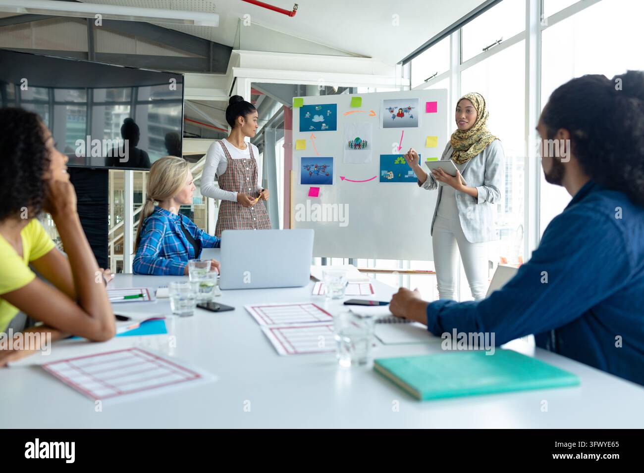Diverse group of college students listening to senior colleague Stock Photo
