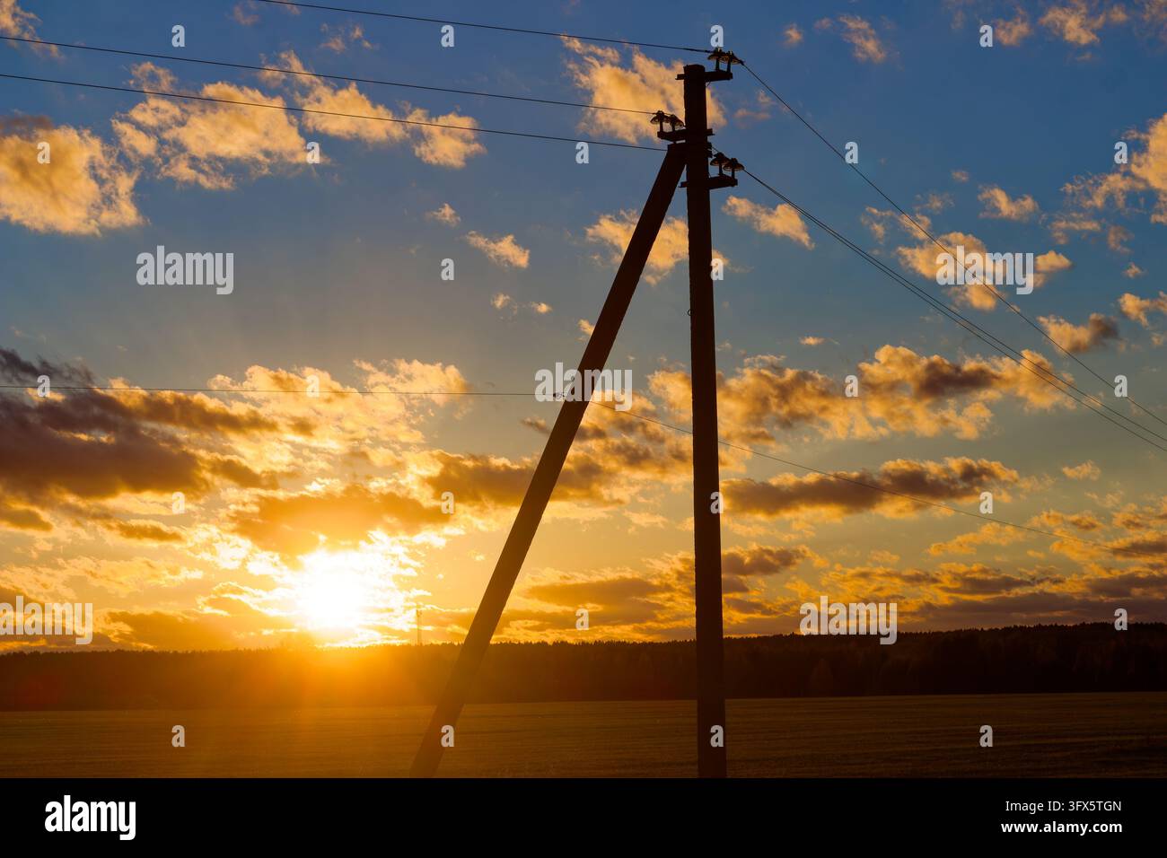 Sundet Line Model Dark wooden utility pole silhouette against vibrant autumn sunset sky ...