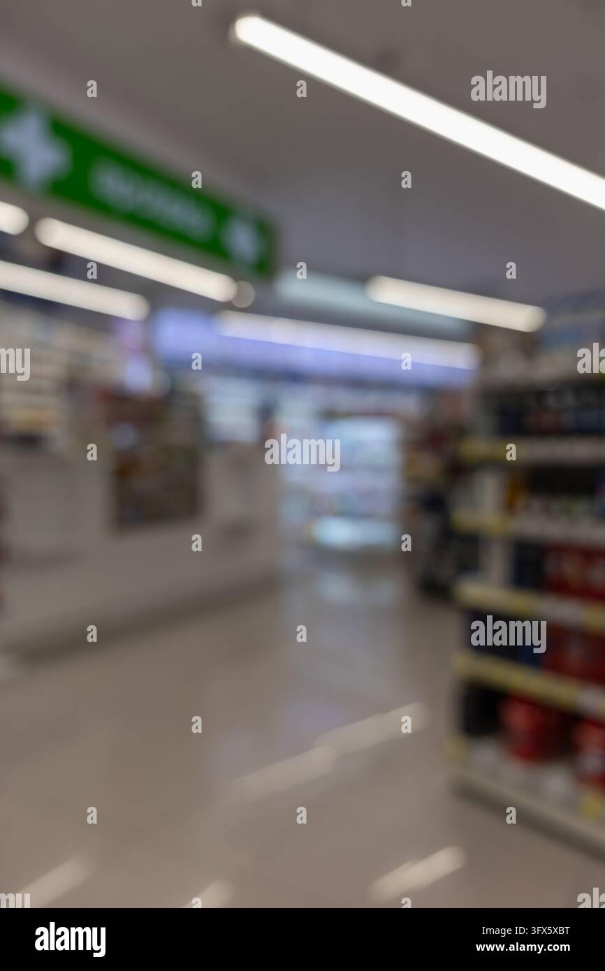 blurred pharmacy interior with shelves, counters, and glowing green ...