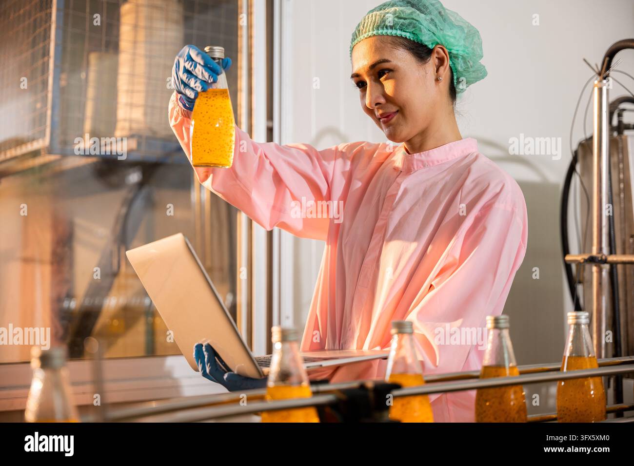 In a beverage factory a woman engineer conducts thorough quality checks ...