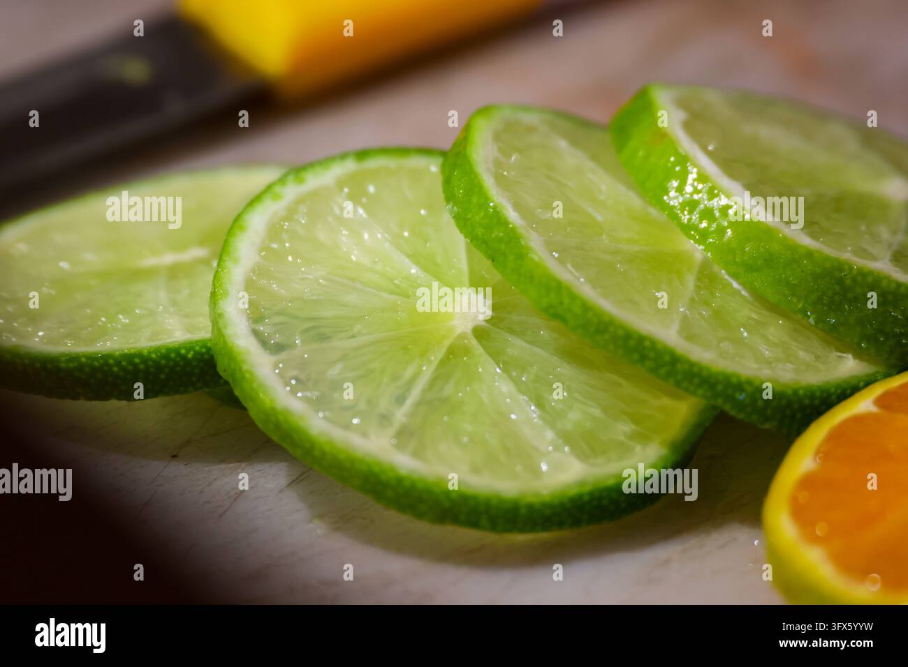 A fresh lime slices with juicy citrus texture on cutting board ...