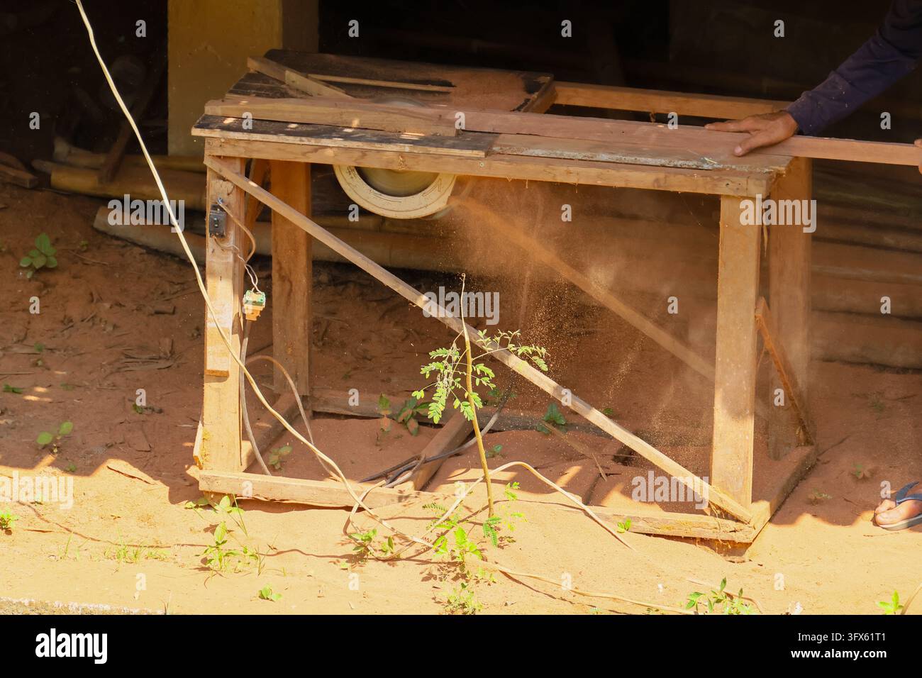 Rustic Asia A rustic wooden workbench with dusty surface stands outdoors beside ...