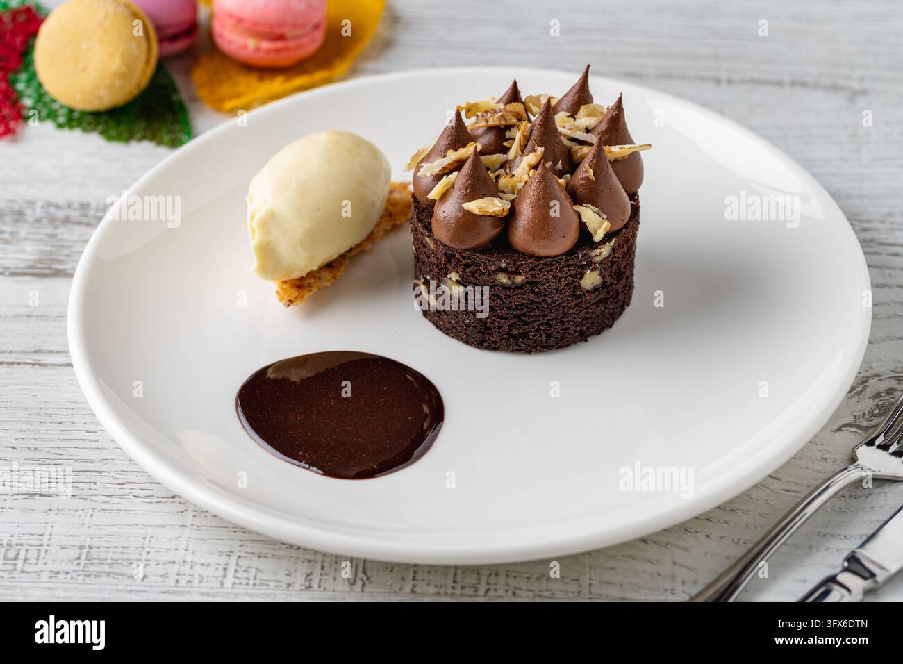 Chocolate brownie cake with ganache peaks, nuts, vanilla ice cream and chocolate sauce Stock Photo