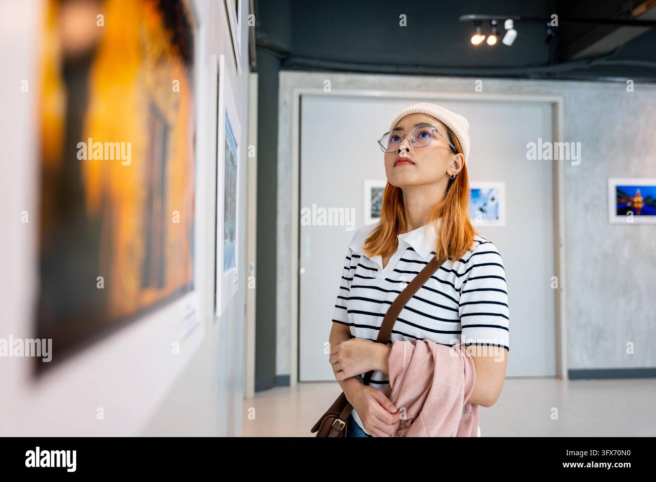 Asian woman standing she looking art gallery in front of colorful ...