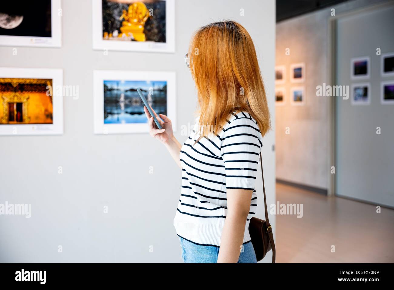 Visitor woman standing takes picture art gallery collection in front ...