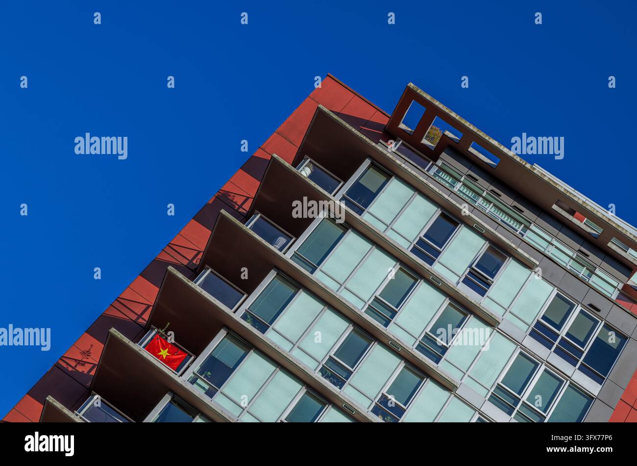 Abstract low angle view of a red modern apartment building with a ...