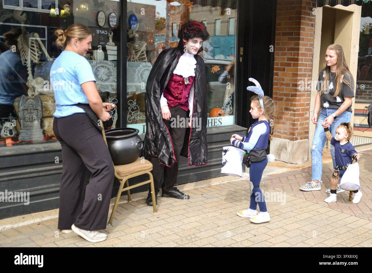 Trick or treaters collect candy from a costumed character during the La ...