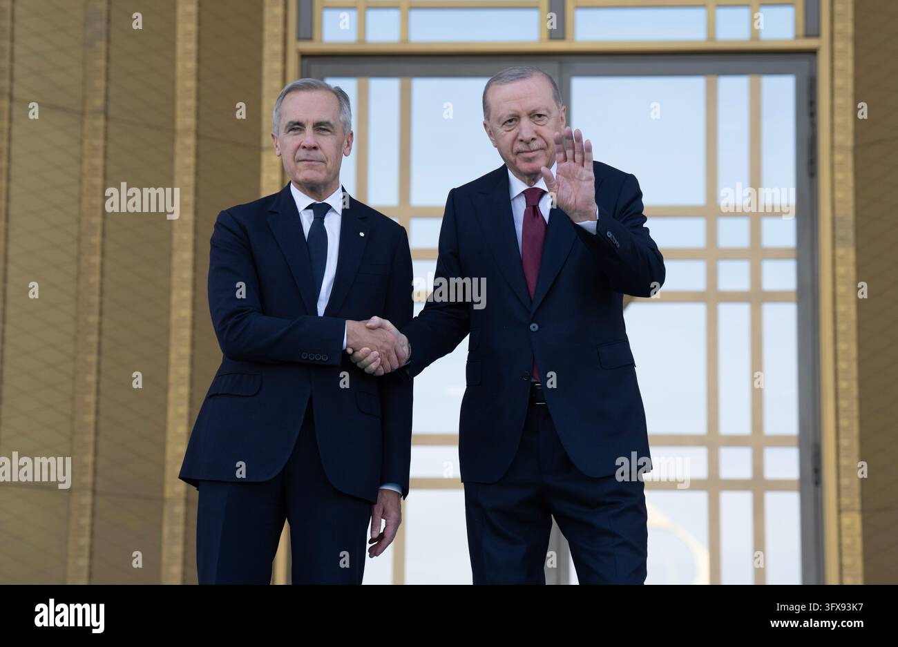 Turkish President Recep Tayyip Erdogan, right, waves as he shakes hands ...