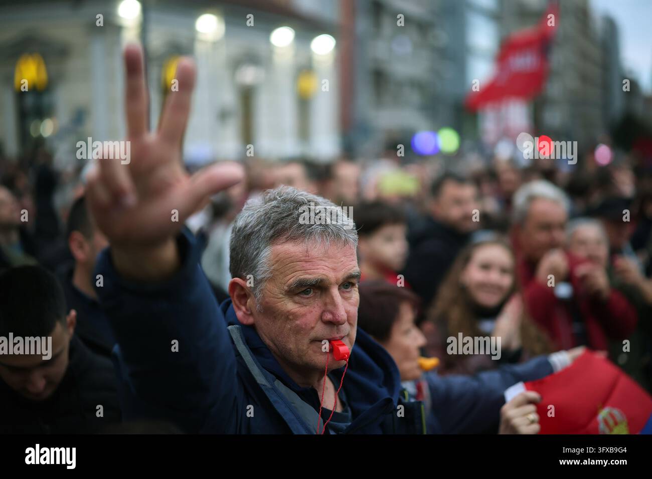 A man blows a whistle as people gather for the final 